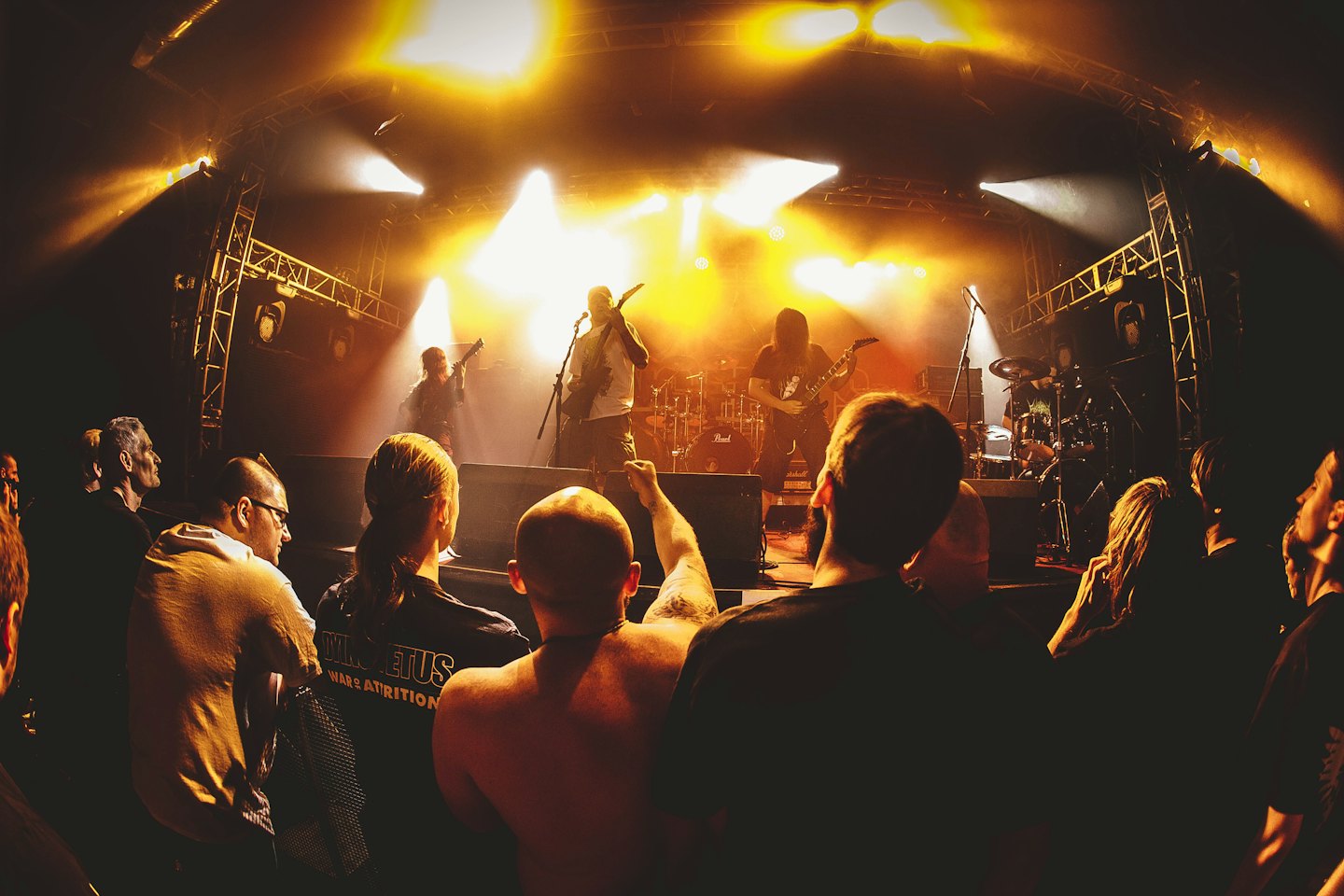 A rock band performs live on stage for a crowd.